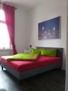- une chambre avec un lit doté de draps rouges et verts et une fenêtre dans l'établissement New Amsterdam, à Quedlinbourg