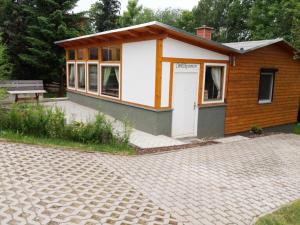 un pequeño edificio con un banco delante en Ferienhaus Bielenski en Blankenburg