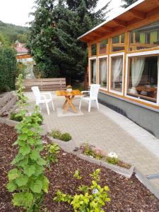 eine Terrasse mit 2 Stühlen, einem Tisch und einer Bank in der Unterkunft Ferienhaus Bielenski in Blankenburg