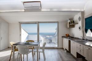 cocina con mesa, sillas y ventana en Casa Belvedere en Agrigento