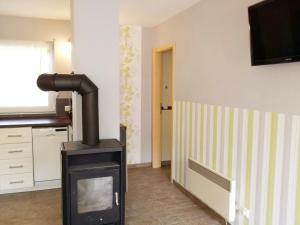 a fireplace in a room with a kitchen and a television at Ferienhaus Bielenski in Blankenburg
