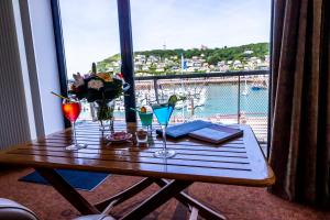 a table with glasses and a view of the ocean at Hotel Le Grand Pavois in Fécamp