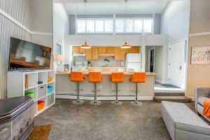 a large kitchen with orange chairs and a counter at Gold Camp Gold Pan Condo: On Shuttle Route in Breckenridge