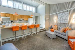 a living room with a couch and a kitchen at Gold Camp Gold Pan Condo: On Shuttle Route in Breckenridge