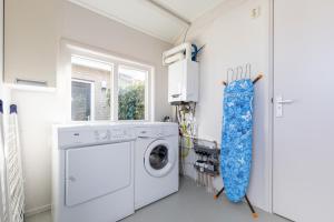 eine Waschküche mit Waschmaschine und Trockner in der Unterkunft T Fiskersplak in Hollum