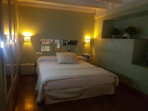 a bedroom with a bed with two lights on the wall at Uman Hotel -Motel- in Buenos Aires