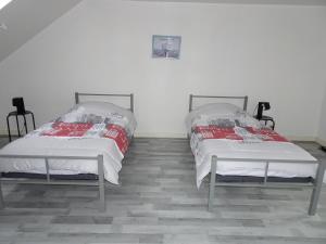 twee bedden naast elkaar in een kamer bij Hébergement Paquebot de Rêve in Saint-Nazaire