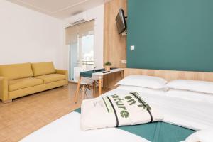 a hotel room with two beds and a couch at Pantheon Square View Komotini in Komotini
