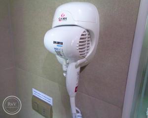 a white hair dryer in a bathroom stall at R&V Apartments in Santiago