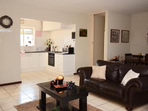 a living room with a couch and a table at Libem Lodge 2 in Edenvale