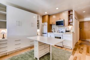 a kitchen with white cabinets and a white table at Cedar Lodge Peak One Studio Condo: Downtown Frisco in Frisco