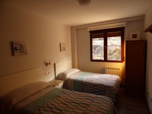 a bedroom with two beds and a window at Apartamento Las Eras in Camarena de la Sierra +28 photos