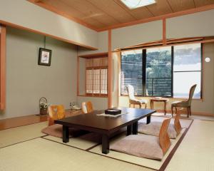 ein Wohnzimmer mit einem Tisch und Stühlen in der Unterkunft Kawayu Onsen Fujiya in Hongu