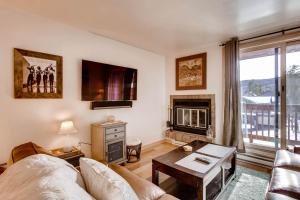 a living room with a couch and a fireplace at Cedar Lodge Peak One Studio Condo: Downtown Frisco in Frisco