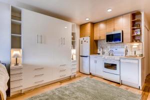 a kitchen with white cabinets and a white refrigerator at Cedar Lodge Peak One Studio Condo: Downtown Frisco in Frisco