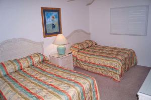 a hotel room with two beds and a lamp at Sungate 402 in Ocean City