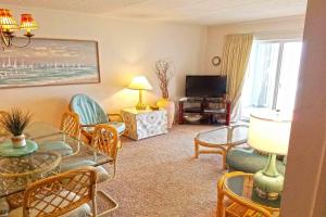a living room with a table and chairs and a television at Sungate 402 in Ocean City