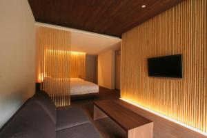 sypialnia z łóżkiem i telewizorem na ścianie w obiekcie Kawayu Onsen Fujiya w mieście Hongu