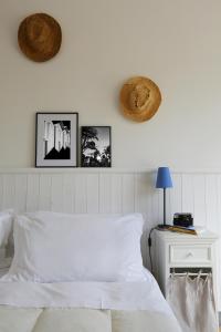 1 dormitorio con 1 cama blanca y 3 cuadros en la pared en Casali Marchigiani - Ville vacanza private con piscina, en Ostra