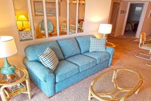 a blue couch in a living room with two tables at Sungate 402 in Ocean City