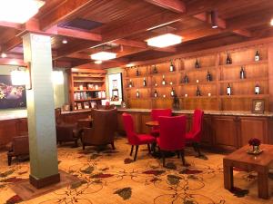 een bar met rode stoelen en een tafel in een kamer bij Hotel Mission De Oro in Santa Nella