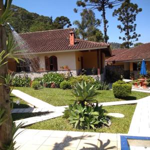 una casa con un jardín delante de ella en Hotel Cantinho de Férias, en Visconde De Maua