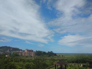 a building in a field with a cloudy sky w obiekcie Agerre Goikoa Agroturismo w mieście Zarautz