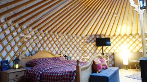 a bedroom with a bed in a yurt at Fichtel-Jurte - Optional mit Hot Tub in Hohenberg an der Eger