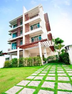 a building with a lawn in front of it at The Meet Green Apartment in Bangkok