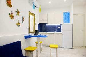a kitchen with a blue table with a laptop on it at Villaggio La Bussola in Paola