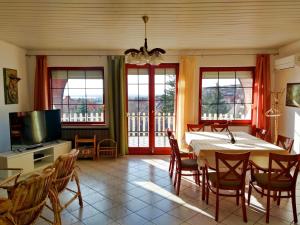 a dining room with a table and chairs and a television at Kati Villa in Vonyarcvashegy