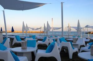 a group of chairs and tables on the beach at Sandy Beach Hotel & Spa - ex Sentido in Larnaca