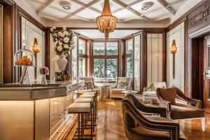 a living room with a bar and chairs at Villa Eden a member of Leading Hotels of the World in Merano