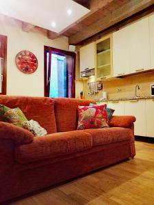 eine braune Couch mit bunten Kissen in der Küche in der Unterkunft San Marco Venice Apartment in Venedig