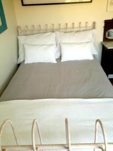 a bed with white sheets and pillows in a room at Kika room Estoril in Estoril