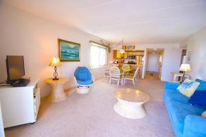 een woonkamer met een blauwe bank en een tafel bij Ocean Hideaway 211 in Ocean City