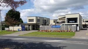 un edificio al lado de una calle con una carretera en ASURE Macy's Motor Inn, en Tauranga