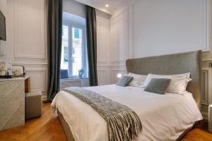 a bedroom with a large white bed with a window at Via Chiodo Luxury Rooms in La Spezia