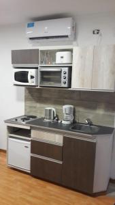 a small kitchen with a stove and a sink at Departamento Estudio 2 in Neuquén