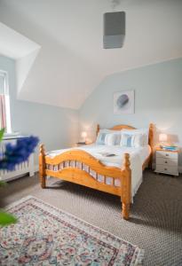 een slaapkamer met een houten bed en een tapijt bij Oar restaurant and Rooms in Doolin