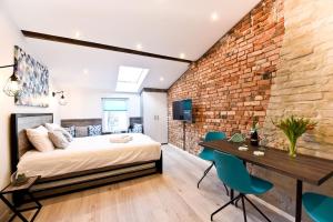 a bedroom with a bed and a brick wall at Steel And Wood Apartment in Toruń
