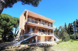 un grande edificio in mattoni con una scala di fronte di Villa Giardino Sa Tiacca a SantʼAndrea