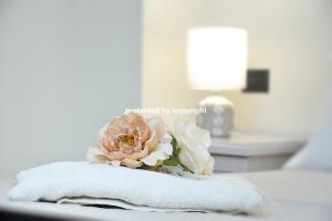 a bouquet of flowers sitting on a towel on a bed at Luxury Penthouse Sea View in Corniglia