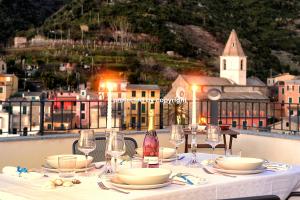 a table with plates and glasses and a bottle of wine at Luxury Penthouse Sea View in Corniglia