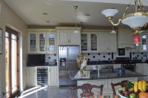 a kitchen with white cabinets and a stainless steel refrigerator at Casa Grande in Angra do Heroísmo