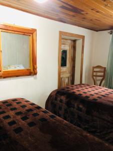 a bedroom with two beds and a mirror at Lindo Departamentito en Creel in Creel