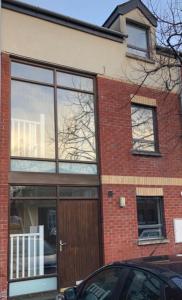 a brick building with a brown door and windows at City Centre Townhouse-3 Bedrooms & Parking - Excellent Location in Belfast