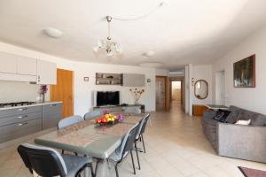 een keuken en woonkamer met een tafel en stoelen bij Appartamento del Cardellini in Santa Caterina +28 foto's