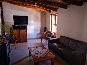 a living room with a couch and a tv at Hostal Elim in San Pedro de Atacama