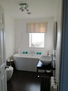uma casa de banho com uma banheira, um WC e um lavatório. em The Fisherman's Snug North Uist em Paible